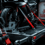 Sangle une moto sur remorque avec sangles rouges et boucle à cliquet
